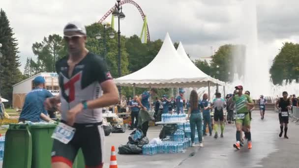 Un groupe d'athlètes forts et robustes boivent de l'eau et se rafraîchissent pendant le triathlon Ironman au ralenti — Video