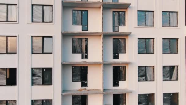 Movimiento hacia arriba edificio sin terminar con ventanas sin esmaltar — Vídeos de Stock