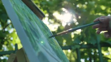 Profesyonel sanatçı boya fırçasıyla tuval yapıyor.