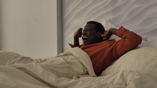 Hombre afroamericano en pijama despierta y abre cortinas — Vídeos de Stock