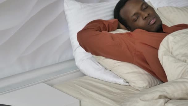 Afro-Américain homme jette et tourne dormir dans le lit à la maison — Video