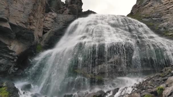 Panorama de una gigantesca cascada de montaña en cámara lenta, el agua cae desde una gran altura en las altas montañas — Vídeo de stock
