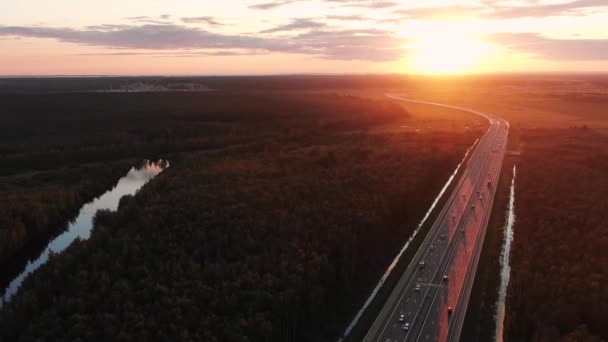Lange snelweg met rijdende auto 's tussen bossen met rivier — Stockvideo