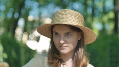 Şapkalı gülümseyen kadın ressam şehir manzarasına bakar ve çizer.