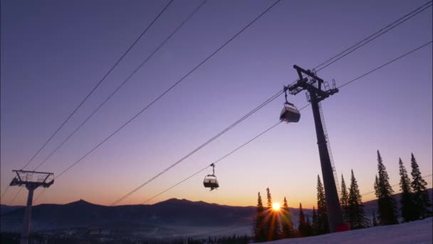 Skilift met bewegende hutten boven besneeuwde berghelling — Stockvideo