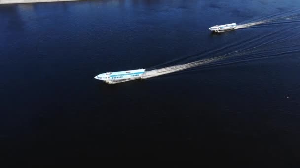 Watertrams varen langs rustige rivier die door de stad loopt — Stockvideo