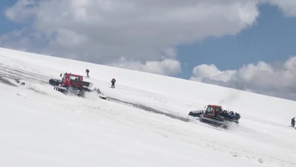 Maszyna gąsienicowa Red snowcat zabiera turystów na stoki Elbrus w celu zaaklimatyzowania się przed wspinaczką na szczyt — Wideo stockowe