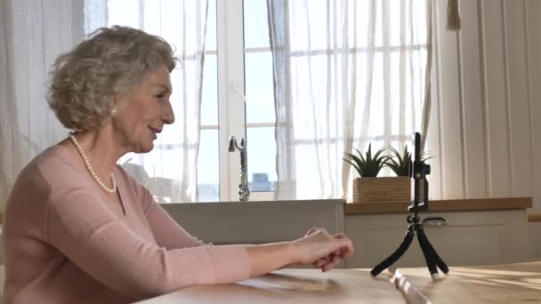 Nice retired woman blogger tells story against smartphone — Stock Video