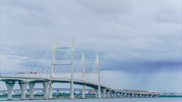 Timelapse de un gran puente moderno con coches en movimiento por la noche contra el fondo de nubes grises lluviosas — Vídeo de stock