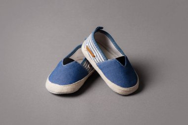 Gri arka planda bebek için küçük ayakkabılar