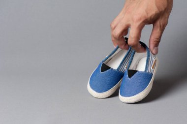 Gri arka planda bebek için küçük ayakkabılar
