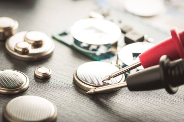 Kol saatleri veya bilgisayar anakartları gibi küçük elektronik cihazları çalıştırmak için kullanılan kapatma düğmesi pili veya saat pili veya bozuk para hücresi.