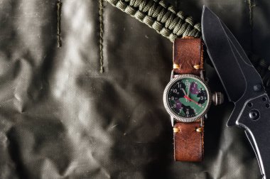 Kamuflaj kadranı ve deri bandı olan eski askeri ya da saha tarzı kol saati..