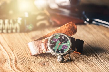 Kamuflaj kadranı ve deri bandı olan eski askeri ya da saha tarzı kol saati..