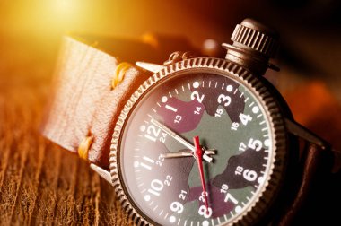 Kamuflaj kadranı ve deri bandı olan eski askeri ya da saha tarzı kol saati..