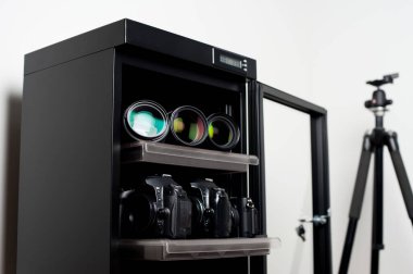 depolama kameraları lensleri ve diğer fotoğraf ekipmanları için kuru kabini nemden arındırın. Sığ alan derinliği, kabinin içindeki ekipmanlara yakın çekim..