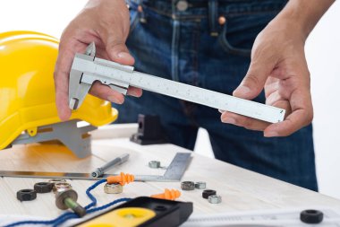 Mühendisin elindeki metal vernier kalibre, vernier caliper doğrusal boyutları ölçmek için kullanılan bir ölçüm aletidir..