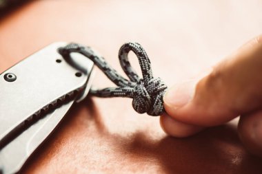 Paraşüt ipinden halat ören adam. Paraşüt kordonu ya da Paraşüt kordonu hafif naylon bir iptir..