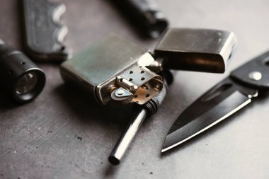 Krom çakmağı kapat ve arka plandaki askeri nesnenin üzerine ön cam koy. Erkekler için EDC.