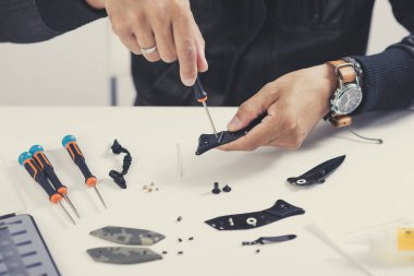 Adam temizlik için bir cep çakısını söküyor. Çakı kıskaçlama ve bakım konsepti.