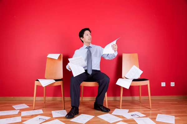 Geschäftsmann Liest Ein Dokument Einem Chaotischen Büro Voller Papiere Auf — Stockfoto