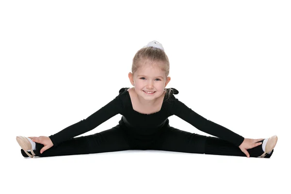 Pretty little girl performs gymnastic exercise — Stock Photo, Image