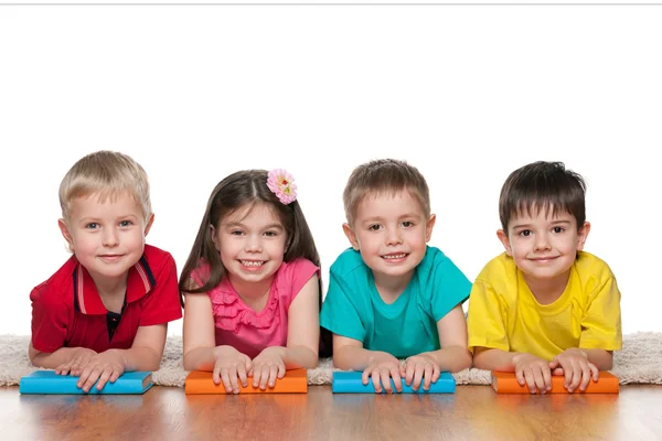 Quatre enfants intelligents avec des livres — Photo