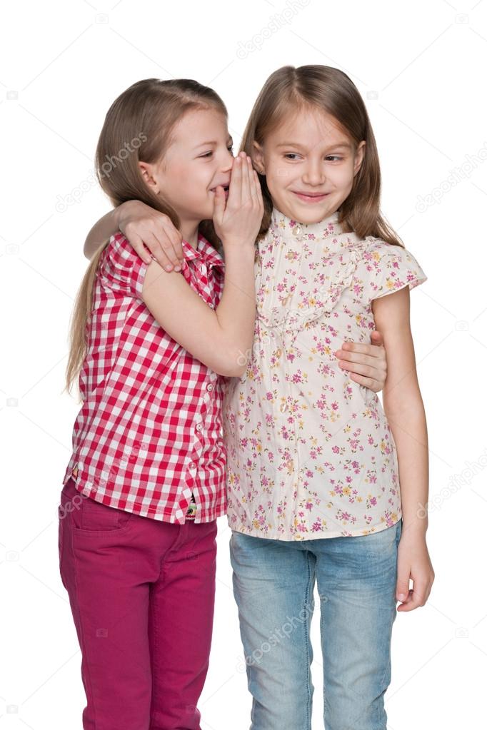 Young girl whispers to her friend
