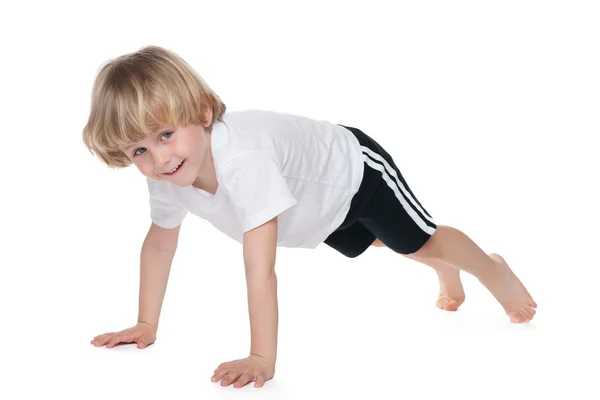 Lindo chico realiza ejercicios de gimnasia — Foto de Stock