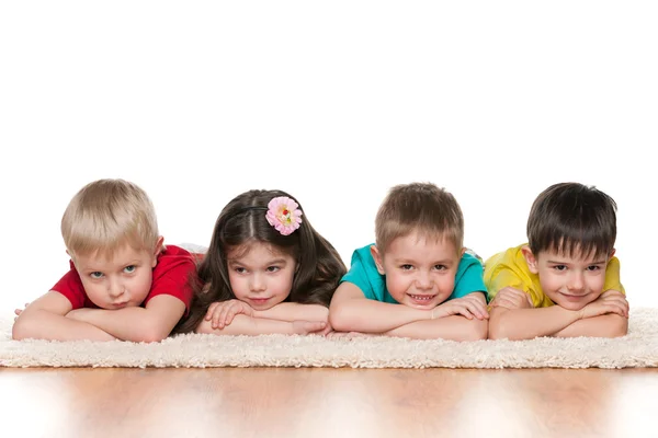 Les enfants s'allongent sur le tapis blanc — Photo