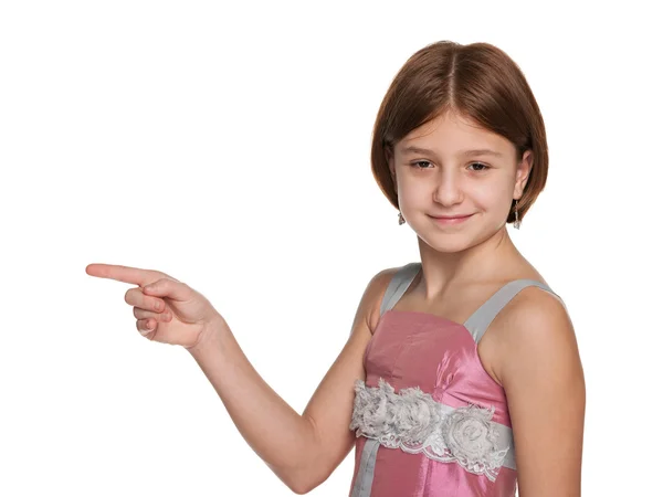 Preteen girl shows her finger to the side — Stock Photo, Image