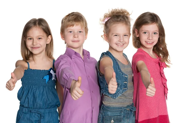 Quattro bambini felici tengono su i pollici — Foto Stock