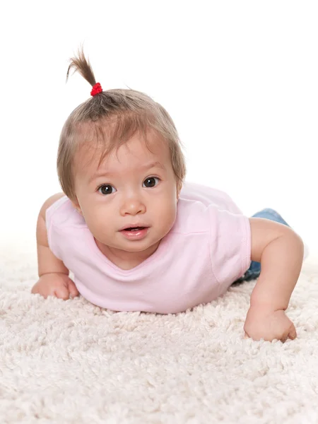 Leuke baby meisje op de witte loper — Stockfoto