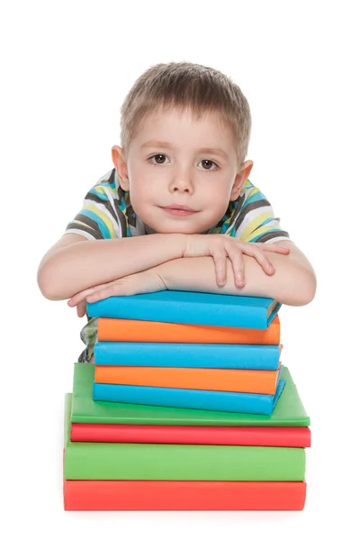 Smart liten pojke nära böcker — Stockfoto