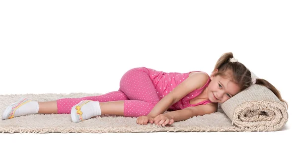 Malá holčička se opírá o koberec — Stock fotografie