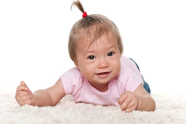 白のカーペットの上に幼児の女の子の笑顔 — ストック写真