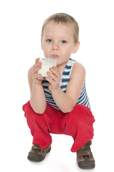 Mały chłopiec ze szklanką mleka. — Zdjęcie stockowe