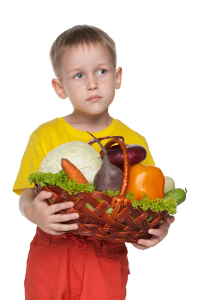 Petit garçon avec un panier avec des légumes — Photo