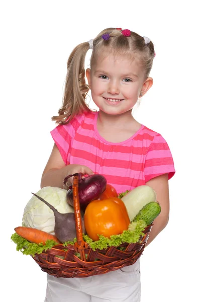 A kislány egy zöldség kosárban — Stock Fotó