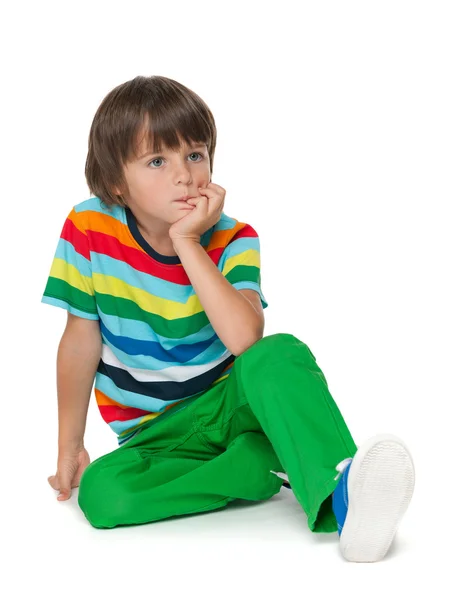 Pensive young boy in a striped shirt — Stock Photo, Image