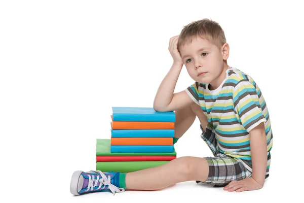 Sad little boy near books — Stock Photo, Image