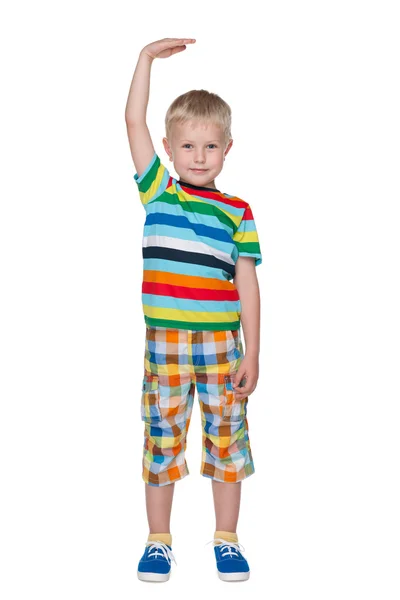 A cute little boy shows how he is tall — Stock Photo, Image