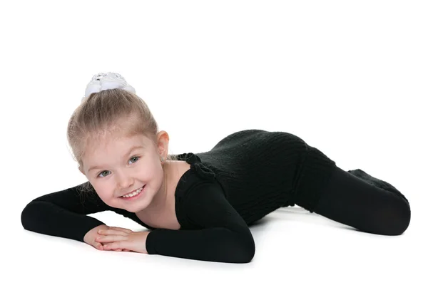 Smiling little girl performs gymnastic exercise — Stock Photo, Image