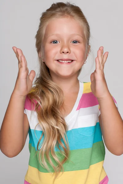 Joyful little girl on the gray background — Stock Photo, Image