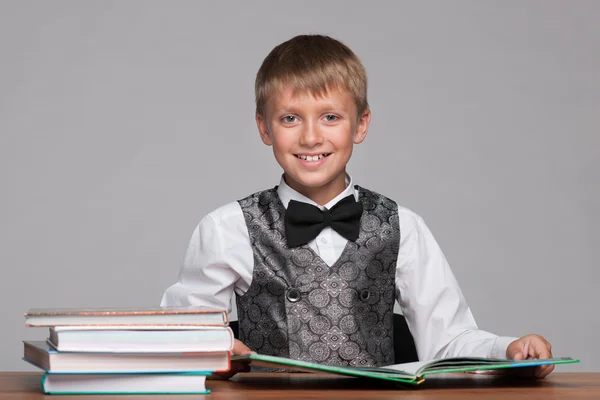 Νεαρό αγόρι στο γραφείο με βιβλία — Φωτογραφία Αρχείου