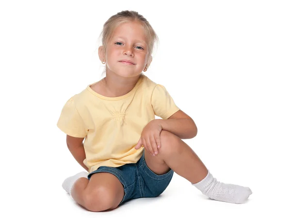 Linda niña se sienta en el fondo blanco — Foto de Stock