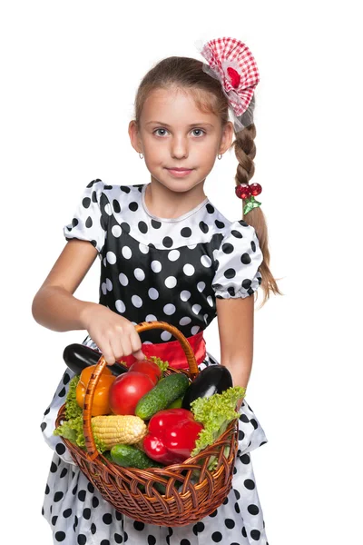 Lachende jong meisje met een mandje met groenten — Stockfoto