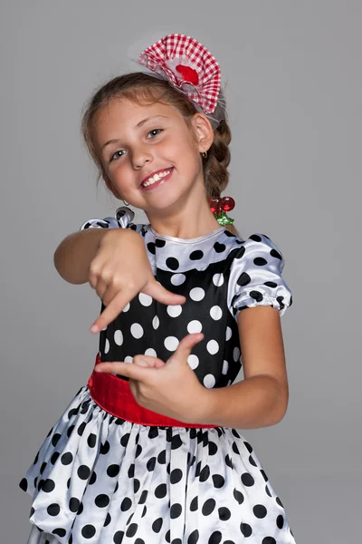 Smiling little girl makes a hands gesture — Stock Photo, Image