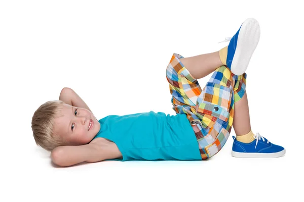 Smiling blond boy rests on the floor — Stock Photo, Image