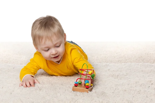 Babyjongen speelt met een stuk speelgoed — Stockfoto